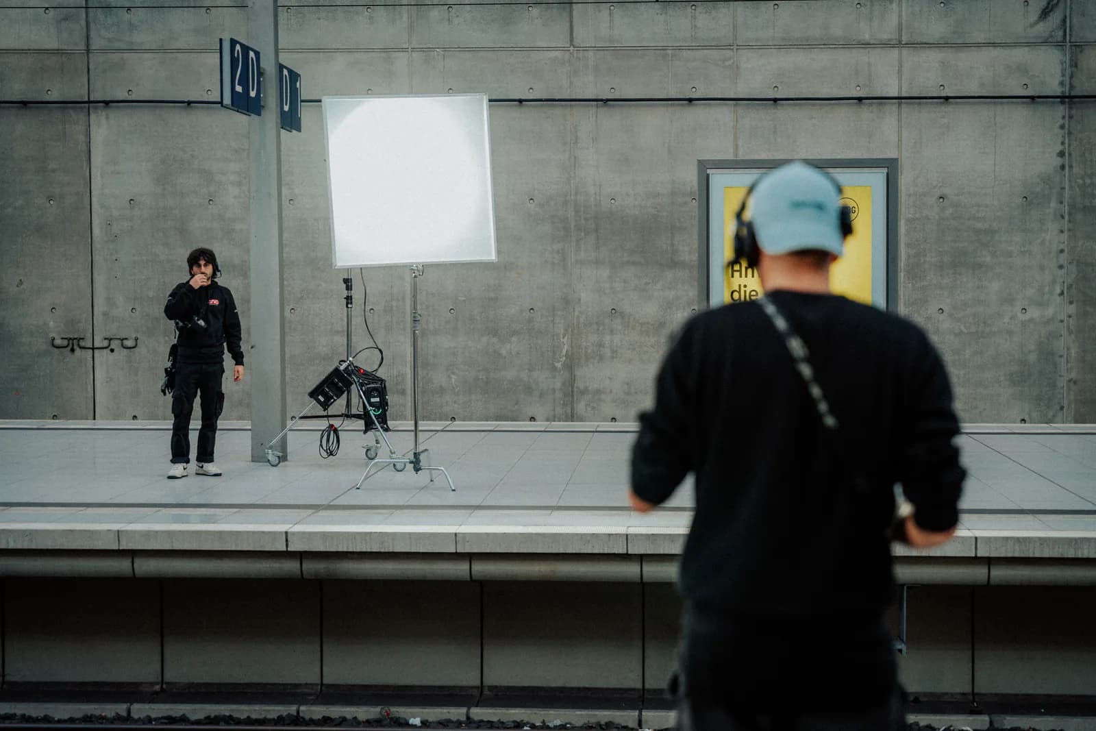 Ausgeleuchtete Drehsituation auf einem Bahnsteig, Flächenlicht vor Betonwand